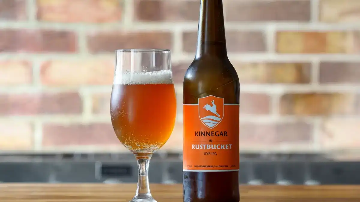 Copo de cerveja Amber Ale de cor âmbar profunda com espuma bege