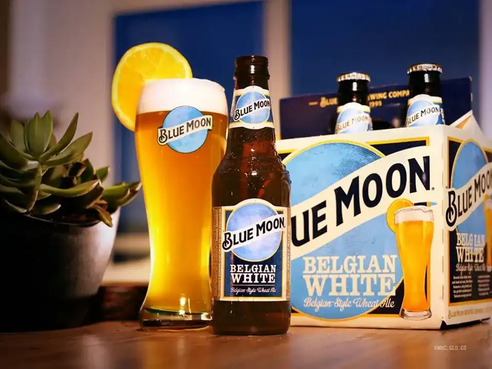 Copo de cerveja Blue Moon turva e dourada com fatia de laranja
