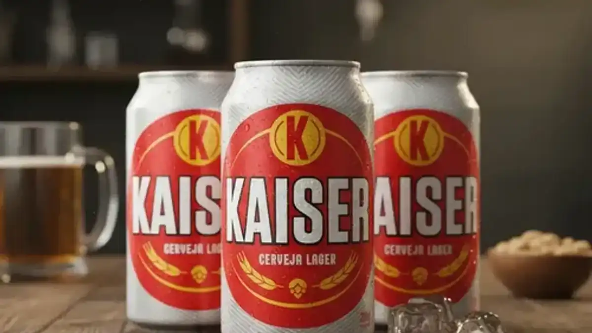 Três latas de Kaiser Cerveja Lager geladas sobre mesa de madeira com gelo
