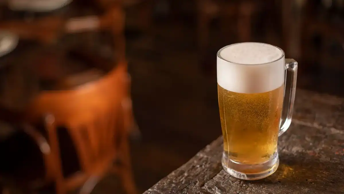 Copo de cerveja Pilsen dourada e brilhante com colarinho de espuma branca